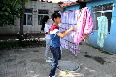 帮助工作人员洗晾床单